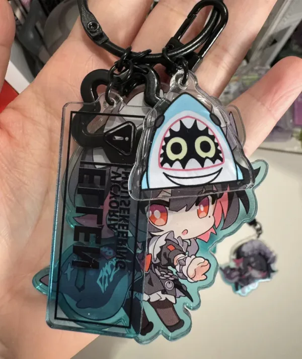 Zenless Zone Zero anime keychain featuring character artwork, acrylic, plush or silicone hanging charm for keys, backpacks, handbags and accessories, collectible HoYoverse game merchandise for fans.