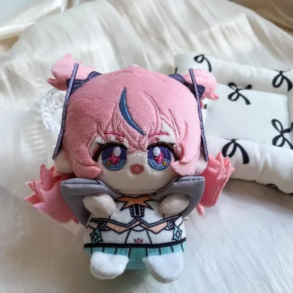 A 10cm sitting chibi plush keychain of Nicole Demara from Zenless Zone Zero, featuring pink hair with a blue streak, large embroidered eyes, and a blue halo accessory on the back.