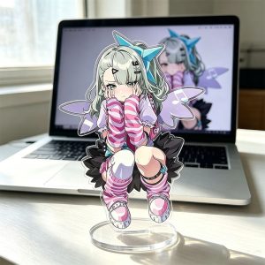 : A clear acrylic standee featuring the Zenless Zone Zero anime character Chinatsu. She is wearing a cute outfit with pink striped arm warmers, a blue star hair clip, and small wings, resting on a round clear acrylic base on a desk in front of a laptop.