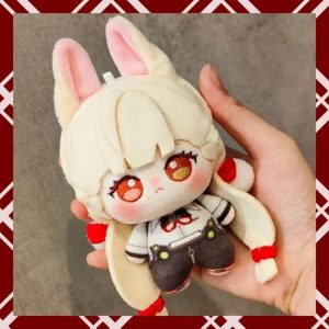 A person holding a 10cm plush cotton doll of the fan-made anime character Alice from Zenless Zone Zero. The chibi doll has blonde hair, fluffy bunny-like ears, large embroidered amber eyes, and wears a white shirt with dark shorts.