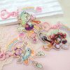 A collection of three retro 90s anime-style holographic acrylic keychains featuring Zenless Zone Zero characters reimagined as magical girls, complete with pink heart clasps and pastel "ANGELS" tags.
