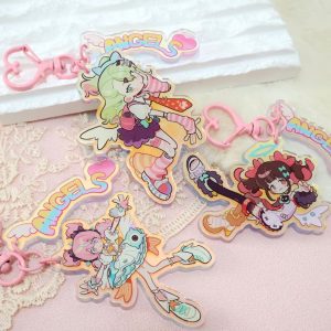 A collection of three retro 90s anime-style holographic acrylic keychains featuring Zenless Zone Zero characters reimagined as magical girls, complete with pink heart clasps and pastel "ANGELS" tags.