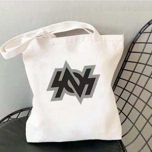 White canvas tote bag printed with Zenless Zone Zero Bangboo artwork and Z.Z.Z text resting on a chair.