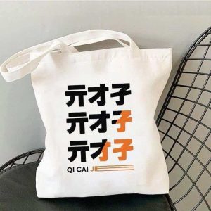 White canvas tote bag printed with Zenless Zone Zero Bangboo artwork and Z.Z.Z text resting on a chair.