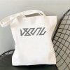 White canvas tote bag printed with Zenless Zone Zero Bangboo artwork and Z.Z.Z text resting on a chair.