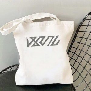 White canvas tote bag printed with Zenless Zone Zero Bangboo artwork and Z.Z.Z text resting on a chair.